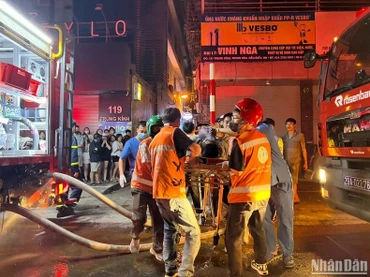 Lực lượng chức năng đưa nạn nhân ra khỏi khỏi đám cháy. 
