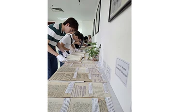 Người xem tìm hiểu nội dung các tài liệu trưng bày.