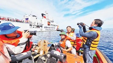 Các phóng viên tác nghiệp trong chuyến công tác trên quần đảo Trường Sa. (Ảnh PHÚ HUÂN)