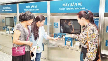 Người dân trải nghiệm tại máy bán vé tự động bên trong ga ngầm Bến Thành, thuộc tuyến Metro số 1. (Ảnh THẾ ANH)
