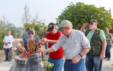 Cựu chiến binh Mỹ thắp hương tại Nghĩa trang Liệt sĩ huyện Sa Thầy, Kon Tum. Ảnh: Đức Bình
