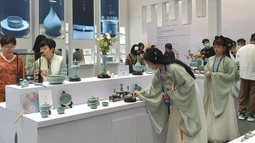 Các thiếu nữ mặc cổ trang bên các sản phẩm gốm sứ Cảnh Đức. (Ảnh: HỒ QUÂN)