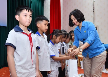 Chủ tịch Công đoàn Báo Nhân Dân Trần Thị Kiều Thanh Bình trao quà tặng các học sinh có hoàn cảnh khó khăn, vươn lên trong học tập tại huyện Na Hang, tỉnh Tuyên Quang.