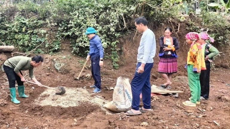 Cán bộ nông nghiệp huyện Tuần Giáo hướng dẫn người dân các bản vùng cao cách trộn đất ươm cây cà-phê giống. (Ảnh: HỒNG NHUNG) img-5605.jpg