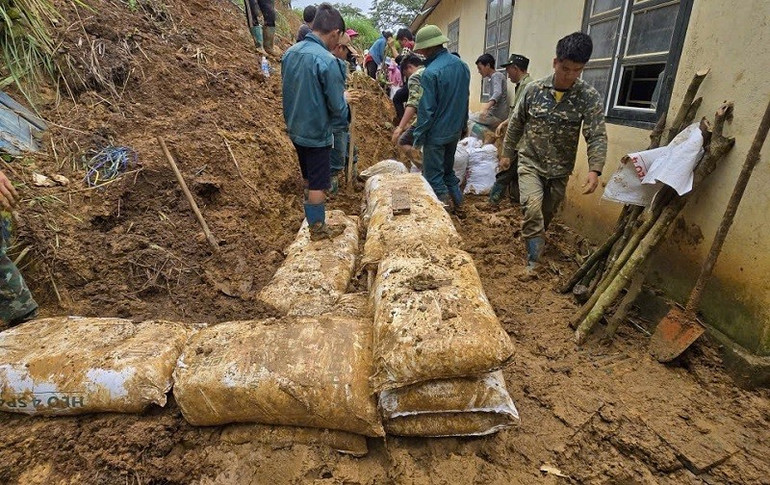 Bộ đội biên phòng Điện Biên cùng nhân dân làm tường kè bằng cách đóng đất chặt vào vỏ bao xi-măng rồi xếp chồng lên nhau. img-7530.jpg