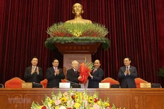 Thay mặt Bộ Chính trị, đồng chí Nguyễn Xuân Phúc, Thủ tướng Chính phủ tặng hoa chúc mừng đồng chí Nguyễn Phú Trọng được tín nhiệm bầu làm Tổng Bí thư Ban Chấp hành Trung ương Đảng Cộng sản Việt Nam khóa XIII. (Ảnh: TRÍ DŨNG/TTXVN)