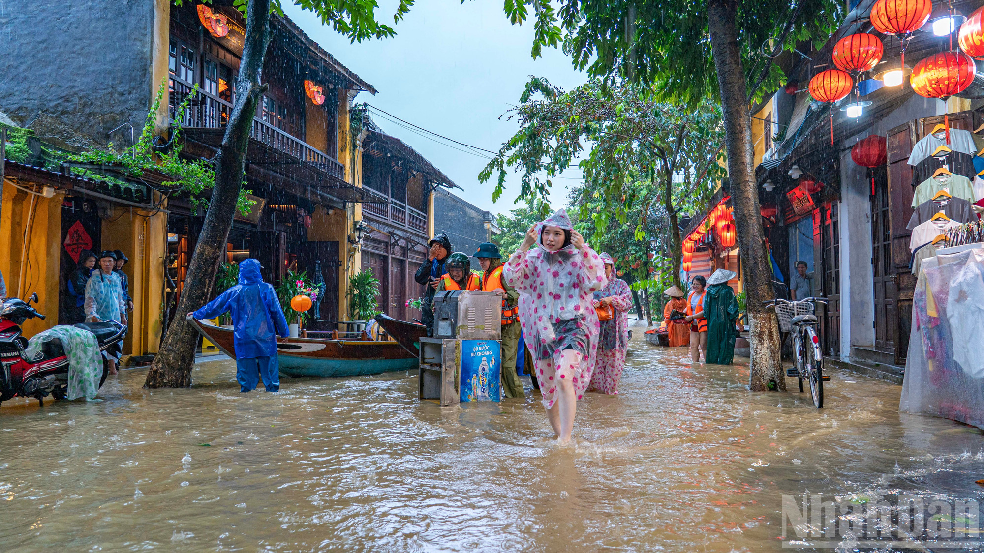 Chính quyền địa phương hỗ trợ người dân tại các khu vực ngập sâu chuyển tài sản bằng ghe tới nơi an toàn. ndo_br_hoi-an-9.jpg