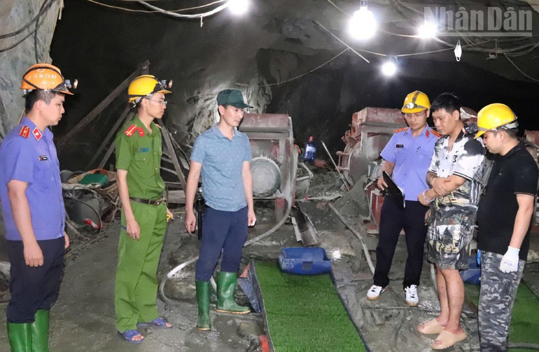 Lực lượng chức năng tiến hành khám nghiệm, kiểm đếm vật chứng tại khu vực hầm khai thác quặng của các đối tượng (đối tượng quản lý Nguyễn Trọng Tiến ở giữa bên phải). ndo_tr_3-2330.jpg