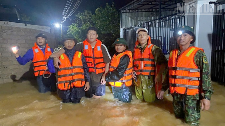 Ông Nguyễn Đức Thắng (thứ 3 từ trái sang) đã được các lực lượng hỗ trợ đưa ra khỏi khu vực mưa lũ. ndo_tr_1.jpg