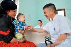 Bác sĩ Nguyễn Duy Đông khám cho bệnh nhi tại Trạm y tế Lũng Cú.