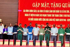 Các đồng chí trong Đoàn công tác Tổng cục Hậu cần-Kỹ thuật Bộ Quốc phòng trao quà tặng các gia đình chính sách, hộ nghèo ở xã Na Son. 