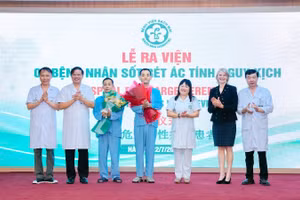 Hai bệnh nhân nhận hoa chúc mừng của thầy thuốc trước khi ra viện.