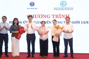 Đại diện lãnh đạo Bộ Y tế, Sở Y tế Hà Nội và Trung tâm điều phối quốc gia về ghép bộ phận cơ thể người tặng hoa tri ân gia đình người hiến tạng. (Ảnh: CƯƠNG QUYẾT)