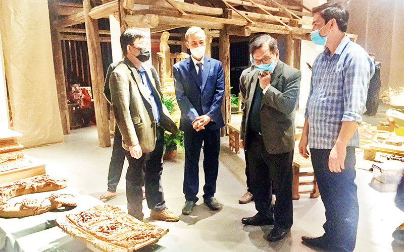 Nghệ nhân Nguyễn Văn Quyết (thứ hai từ trái sang) trao đổi với các nhà nghiên cứu về điêu khắc Việt Nam truyền thống. 