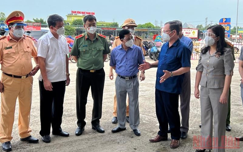 Lãnh đạo Trung tâm Y tế thị xã Nghi Sơn báo cáo thực thi các biện pháp phòng, chống dịch tại khu vực chốt kiểm soát Khe nước lạnh. (Ảnh: MAI LUẬN) 