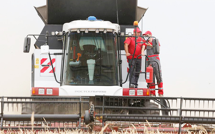 Người dân Nga vận hành máy gặt đập liên hợp. Ảnh: TASS