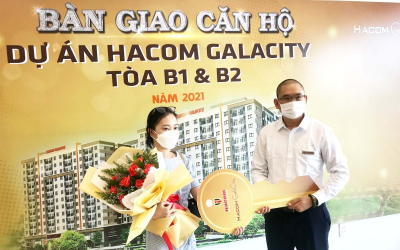 Đại diện chủ đầu tư trao chìa khóa và chúc mừng người có thu nhập thấp nhận căn hộ mới.