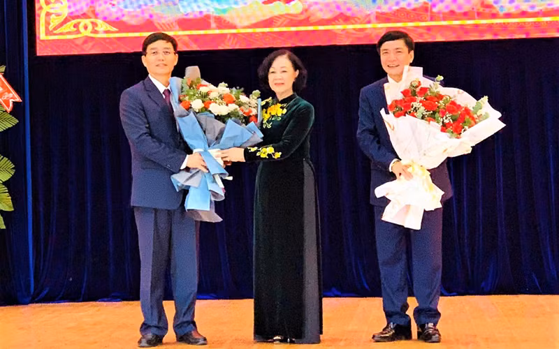 Đồng chí Trương Thị Mai tặng hoa chúc mừng đồng chí Nguyễn Đình Trung (bìa trái) và đồng chí Bùi Văn Cường (bìa phải).