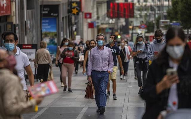 Người đi bộ đeo khẩu trang để phòng lây lan Covid-19 tại khu vực trung tâm Madrid, Tây Ban Nha. (Ảnh: AP)