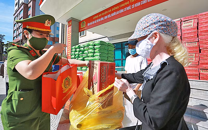 Các chiến sĩ công an quận Hà Đông trao quà tặng người dân có hoàn cảnh khó khăn.