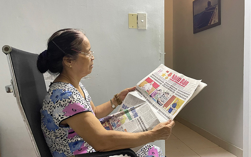 Một bạn đọc tại TP Thủ Đức, TP Hồ Chí Minh đọc Báo Nhân Dân khi thực hiện giãn cách xã hội.