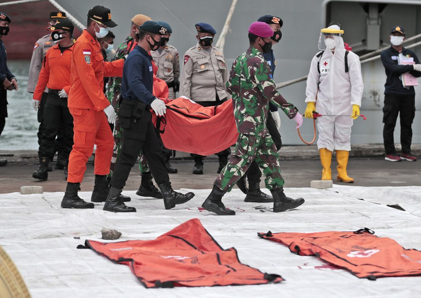 Lực lượng cứu nạn di chuyển túi chứa mảnh vỡ máy bay và phần thi thể người đến cảng Tanjung Priok. (Ảnh: AP)