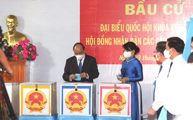 Chủ tịch nước Nguyễn Xuân Phúc cùng phu nhân bỏ phiếu tại khu vực bỏ phiếu số 041, đơn vị bầu cử số 9, thị trấn Củ Chi, huyện Củ Chi, TP Hồ Chí Minh.