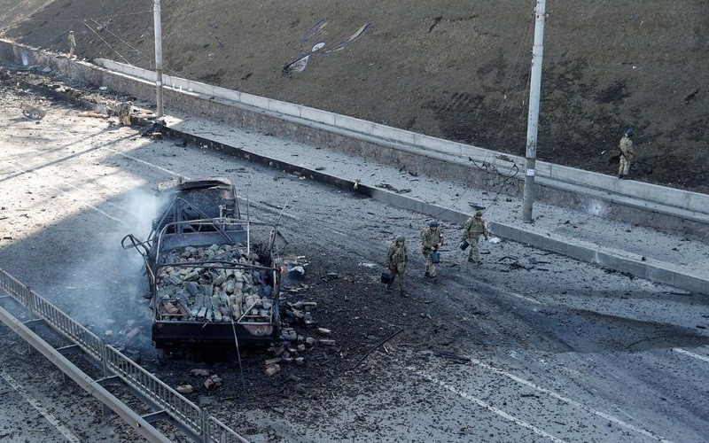 Binh sĩ Ukraine di chuyển qua 1 chiếc xe bị hư hỏng tại khu vực giao tranh với quân đội Nga ở thủ đô Kiev, Ukraine, ngày 26/2/2022. (Ảnh: Reuters)