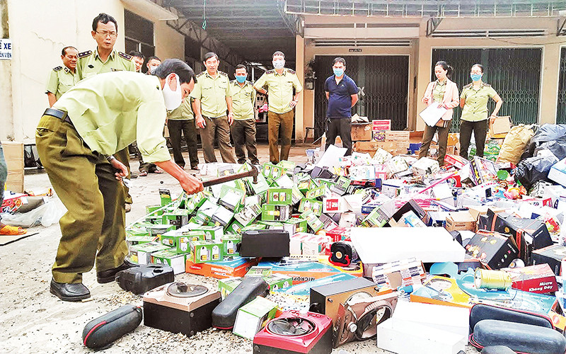 Lực lượng chức năng Gia Lai tiến hành tiêu hủy hàng giả, nhái. Ảnh | Hà Ðinh