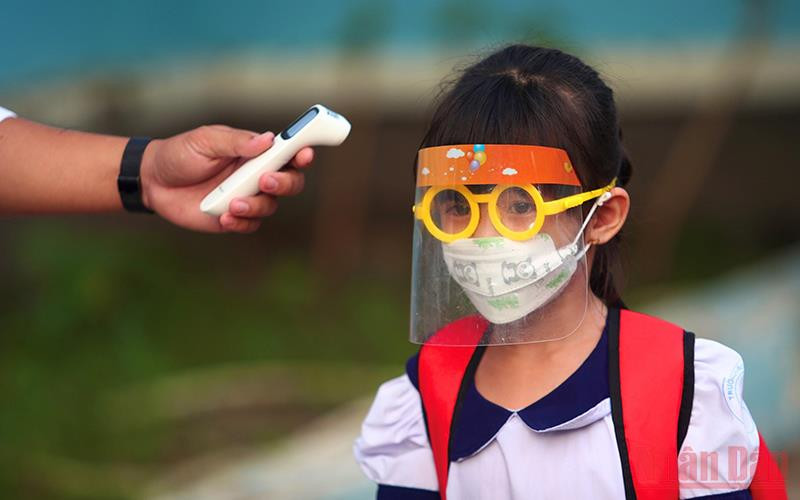 Đo thân nhiệt cho học sinh trước khi vào Trường tiểu học Thạnh An, huyện Cần Giờ, TP Hồ Chí Minh. (Ảnh: HẢI LONG)