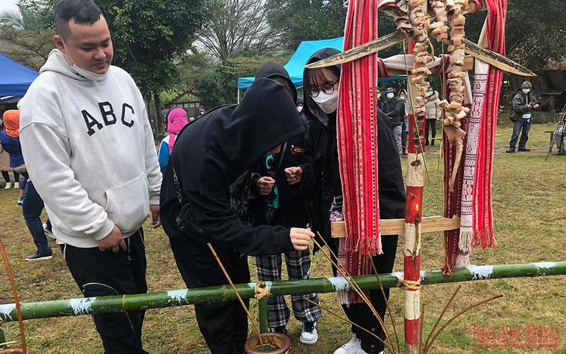 Du khách uống thử rượu cần tại Nhà người Ba Na trong dịp đầu năm mới.