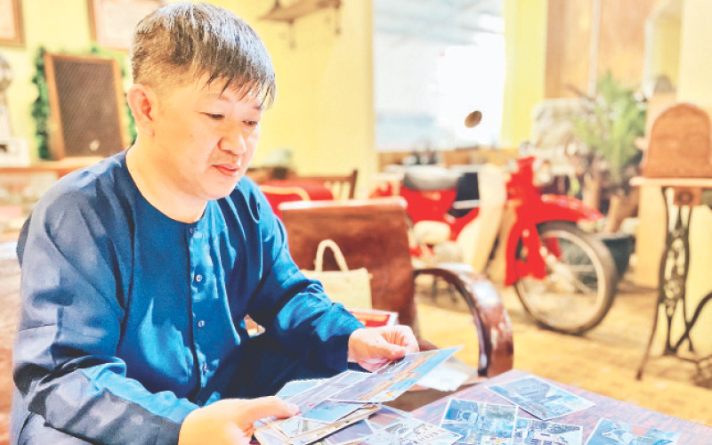 Nhà sưu tầm Huỳnh Minh Hiệp bên những hiện vật trong bộ sưu tập về dịch Covid-19 tại TP Hồ Chí Minh.