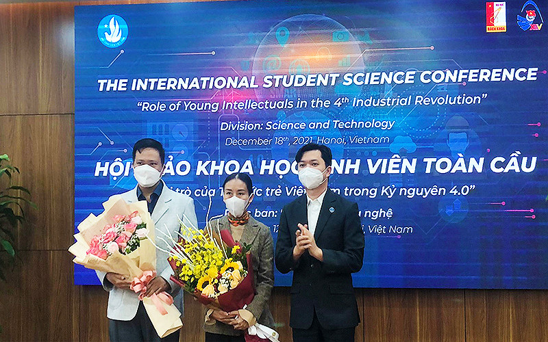 Đồng chí Nguyễn Minh Triết (bên phải trong ảnh) trao hoa tặng các đại biểu trí thức trẻ tham gia Hội thảo tại đầu cầu thành phố Hà Nội.