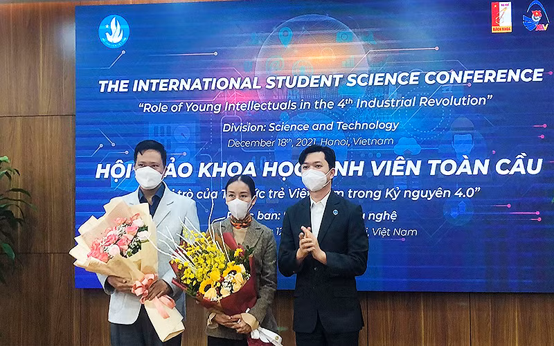 Đồng chí Nguyễn Minh Triết (bên phải trong ảnh) trao hoa tặng các đại biểu trí thức trẻ tham gia Hội thảo tại đầu cầu thành phố Hà Nội.