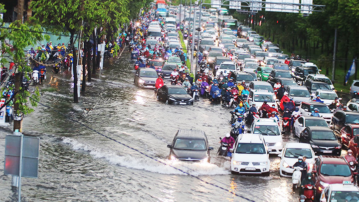 Dòng xe nối đuôi nhau trên đoạn đường ngập nước.