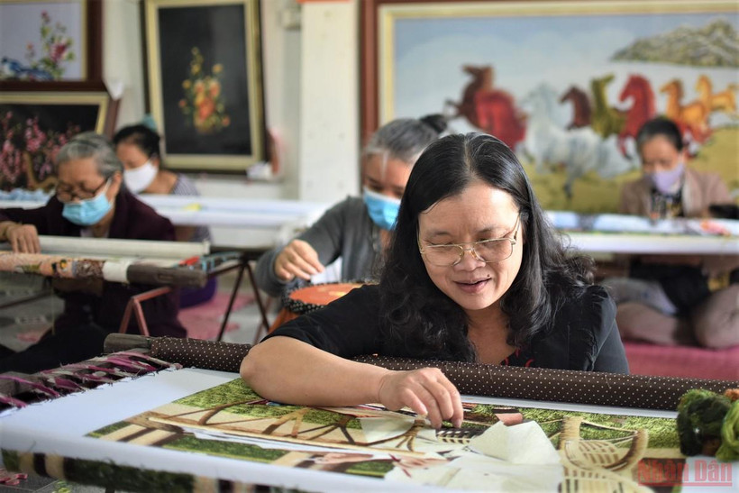 Nghệ nhân Hoàng Thị Khương bên tác phẩm sắp hoàn thiện. (Ảnh: Minh Duy)