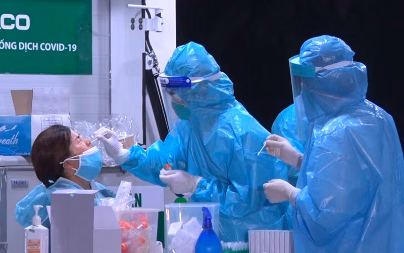 Cán bộ y tế lấy mẫu xét nghiệm của công dân về từ Nhật Bản.