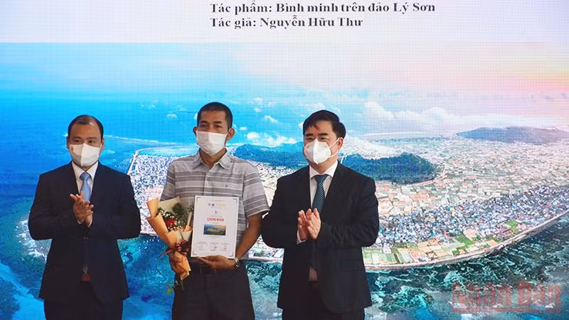 Ông Lê Hải Bình (bên trái) và PGS, TS Phạm Minh Tuấn trao giải nhất cho tác phẩm "Bình minh trên đảo Lý Sơn" của tác giả Nguyễn Hữu Thư.