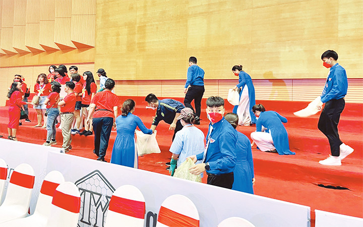 Tình nguyện viên quận Long Biên vệ sinh khu vực khán đài.