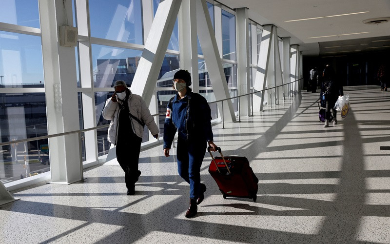 Hành khách đeo khẩu trang di chuyển tại sân bay quốc tế JFK ở New York, Mỹ, ngày 16/11/2021. (Ảnh: Reuters)