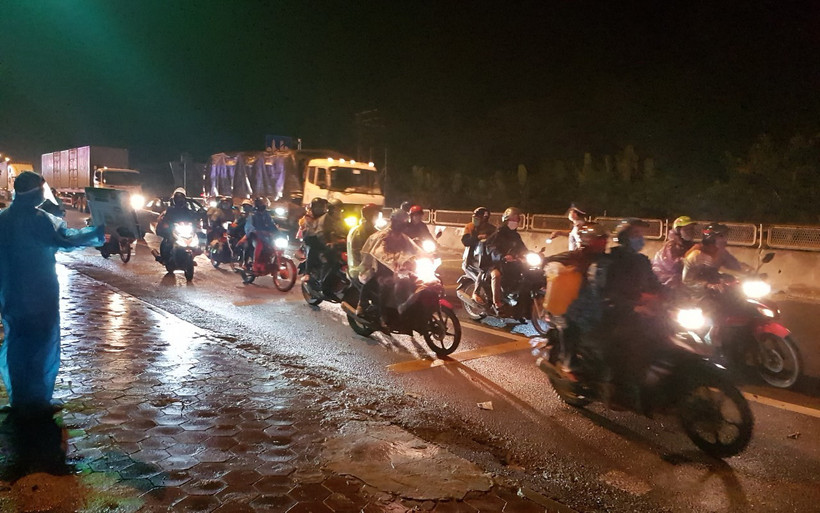 Đoàn xe máy của người dân di chuyển về quê qua chốt kiểm dịch dốc Xây (Ninh Bình).