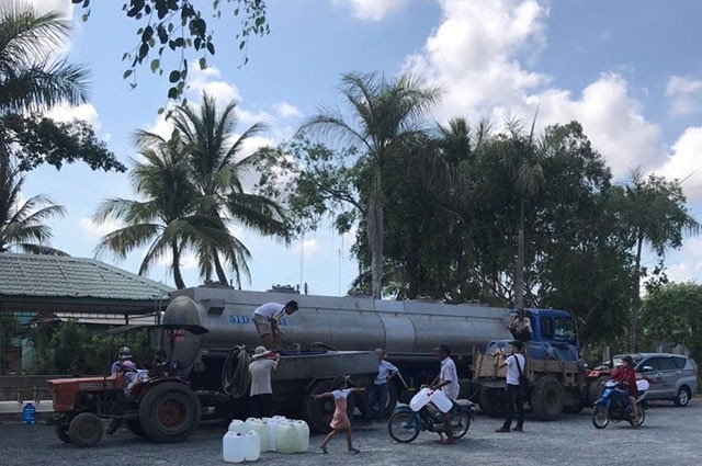 Người dân đến nhận nước miễn phí sáng 17-5.