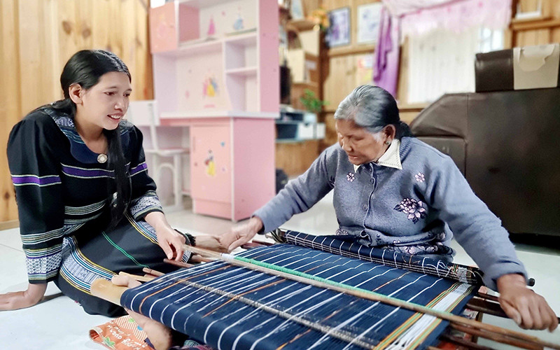 Nghệ nhân Ưu tú Ka Glòng ở Đưng K'Nớ truyền nghề cho con gái.