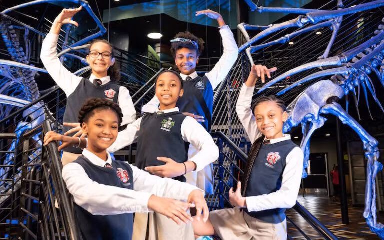 Học viên Học viện Ron Clark bên cầu thang rồng - một trong những nét kiến trúc đặc trưng của ngôi trường.