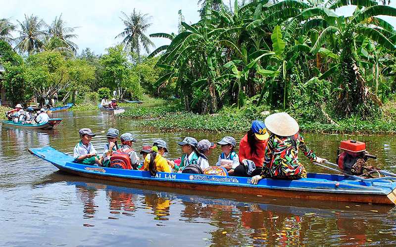 Học sinh tiểu học vùng sâu của huyện Trần Văn Thời, tỉnh Cà Mau đến trường trong năm học mới (Ảnh tư liệu năm 2018). 