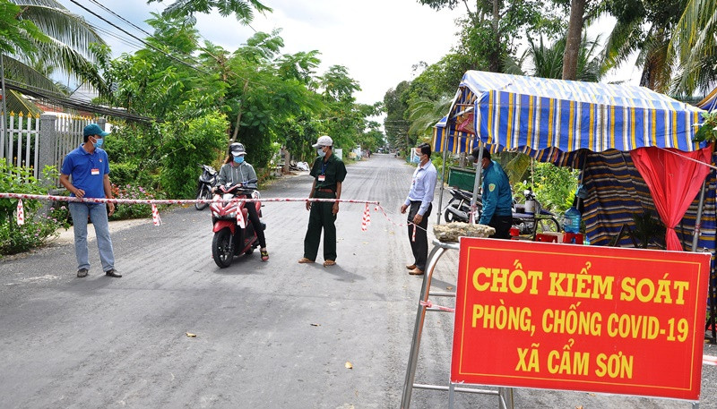 Người dân và lực lượng chức năng bảo vệ chốt “vùng xanh” tại xã Cẩm Sơn, huyện Cai Lậy (Tiền Giang).
