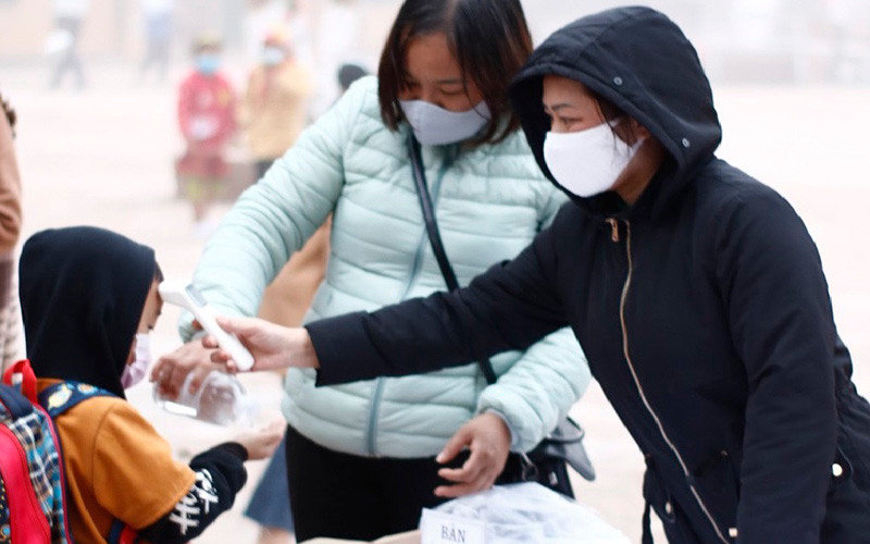 Mỗi học sinh Trường Phổ thông Dân tộc bán trú Trần Văn Thọ đều cô giáo đo thân nhiệt, hướng dẫn sát khuẩn tay trước khi vào trường.