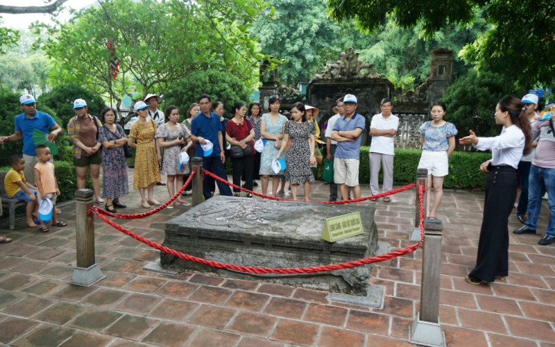 Khách du lịch tham quan “Long sàng” trước nghi môn ngoại đền vua Đinh.