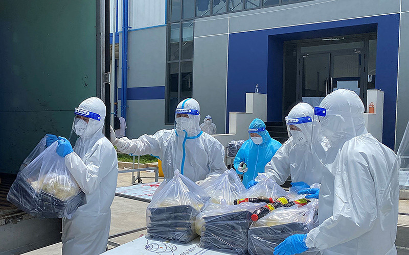 Các F0 khỏi bệnh hỗ trợ đưa cơm cho bệnh nhân tại Khu điều trị bệnh nhân Covid-19 Thới Hòa (Bình Dương).