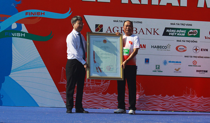 Lãnh đạo Cục Sở hữu trí tuệ trao chứng nhận đăng ký chỉ dẫn địa lý sản phẩm tỏi Lý Sơn cho lãnh đạo huyện Lý Sơn. (Ảnh: HIỂN CỪ)